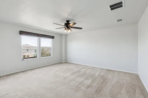 an empty room with windows and ceiling fan