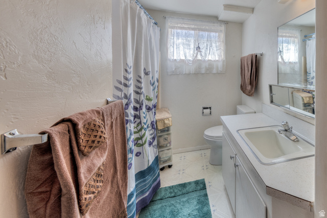 738 Locust Lane Moab, UT 84532 - Photo 16 of 25 Full bathroom with vanity, a shower with curtain, plenty of natural light, and a textured wall