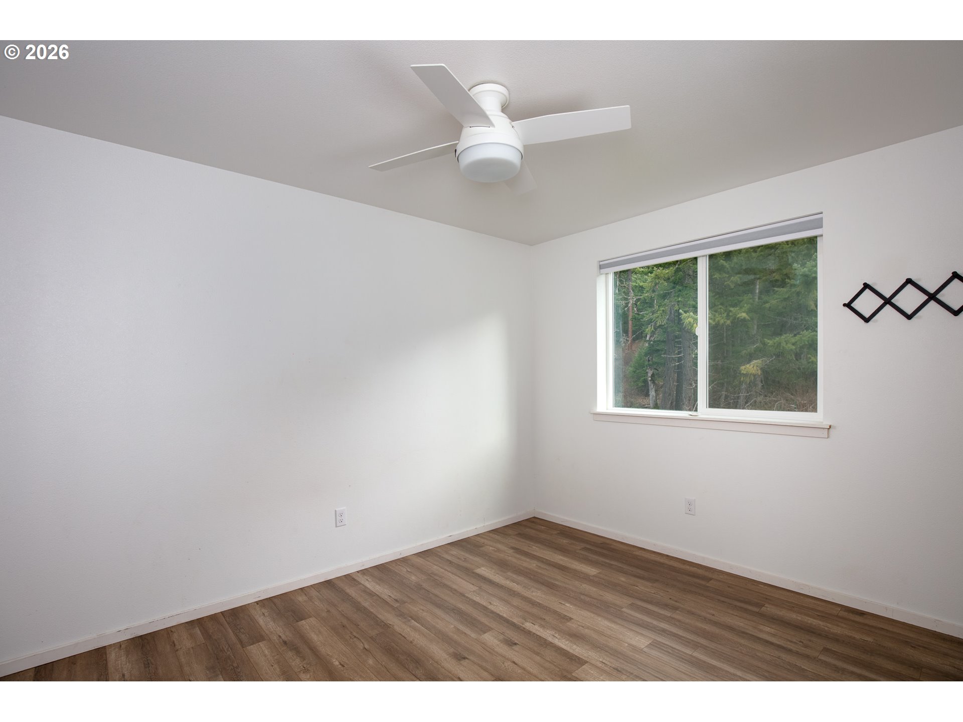 244 Lyons Road White Salmon, WA 98672 - Photo 12 of 22 an empty room with wooden floor and windows
