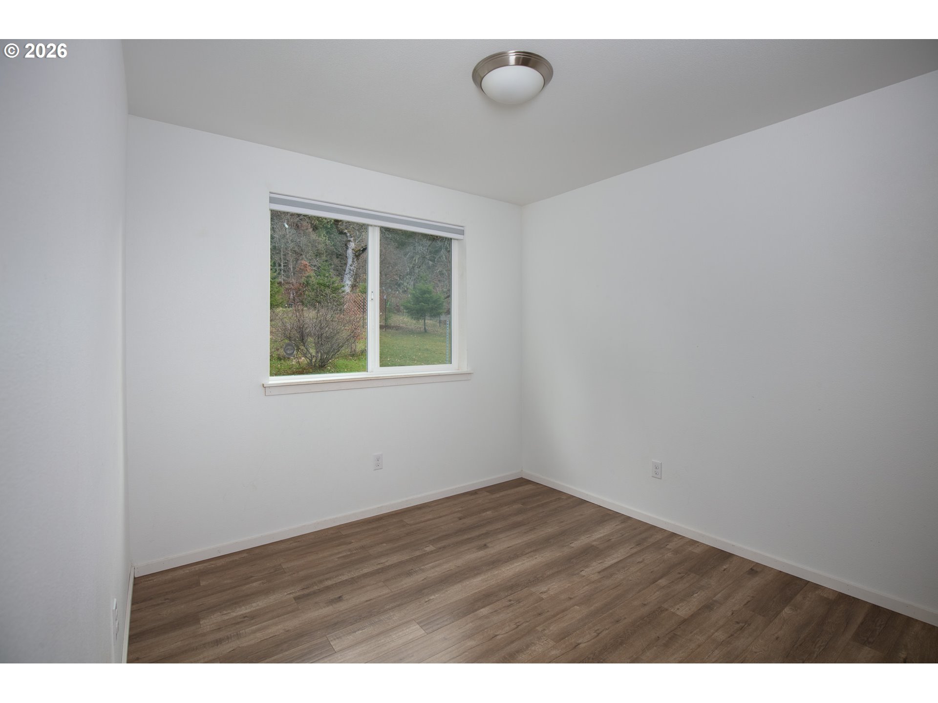 244 Lyons Road White Salmon, WA 98672 - Photo 13 of 22 a view of an empty room with wooden floor and a window