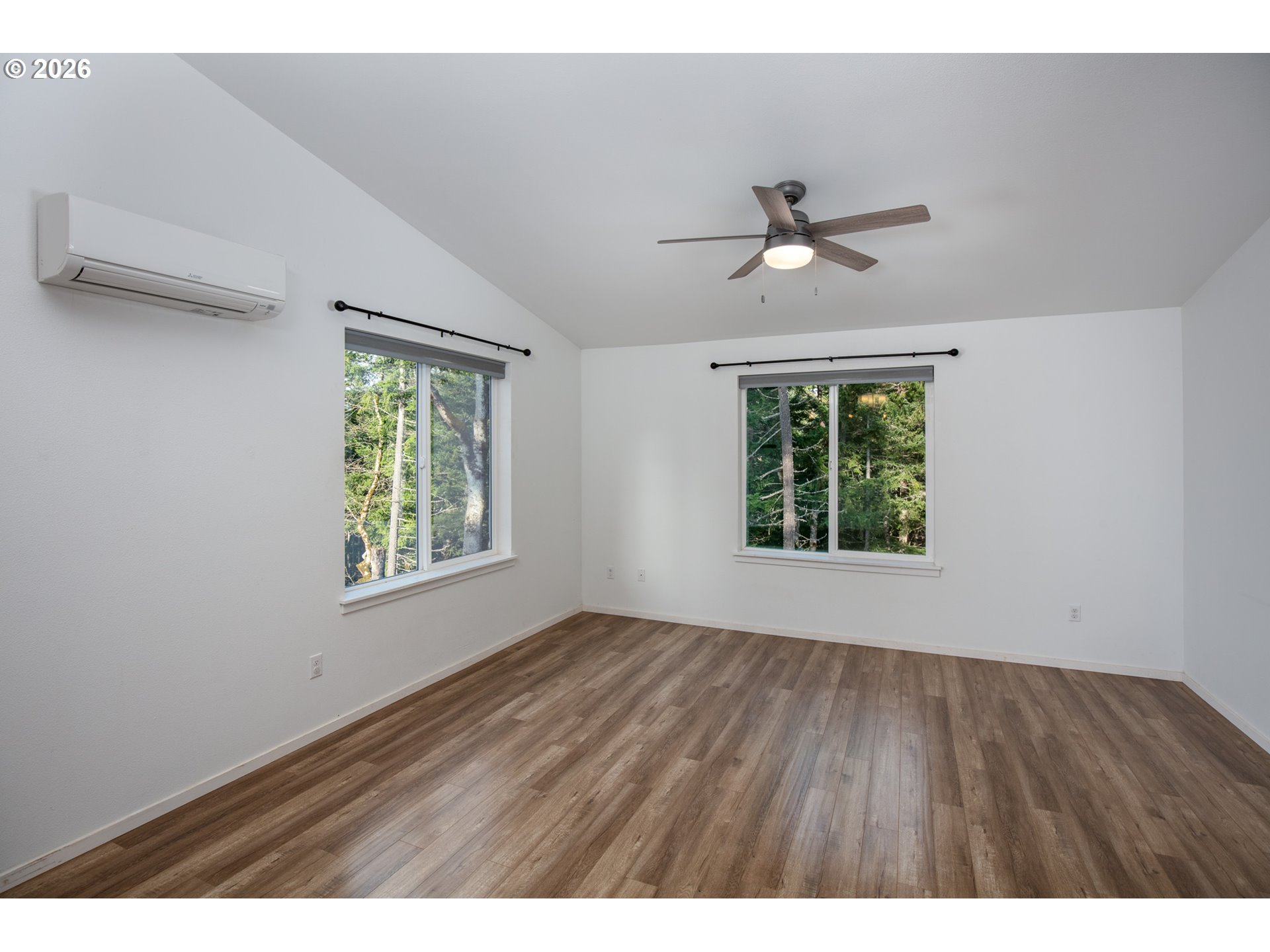 244 Lyons Road White Salmon, WA 98672 - Photo 5 of 22 an empty room with wooden floor ceiling fan and windows