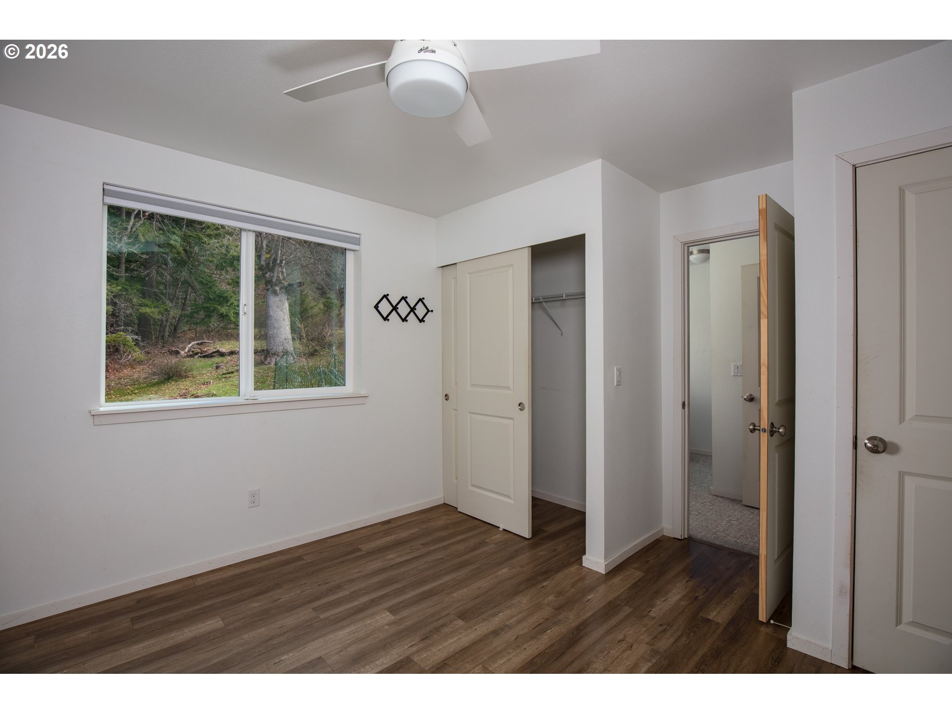 244 Lyons Road White Salmon, WA 98672 - Photo 9 of 22 a view of an empty room with wooden floor and a window