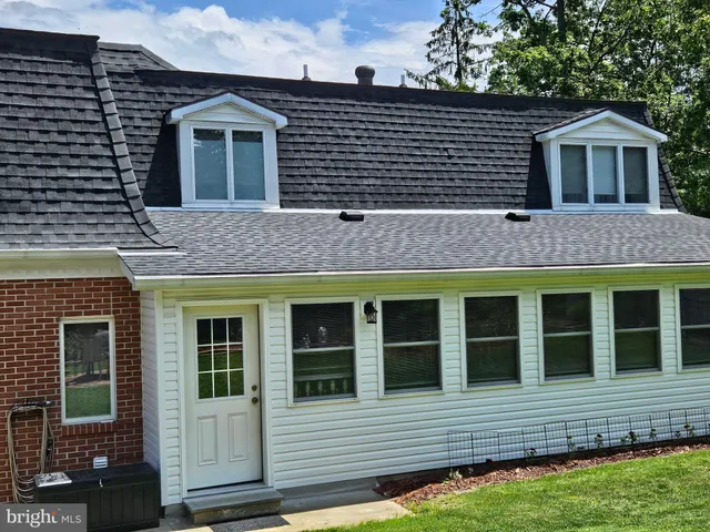 a view of a brick house with a yard and potted plants