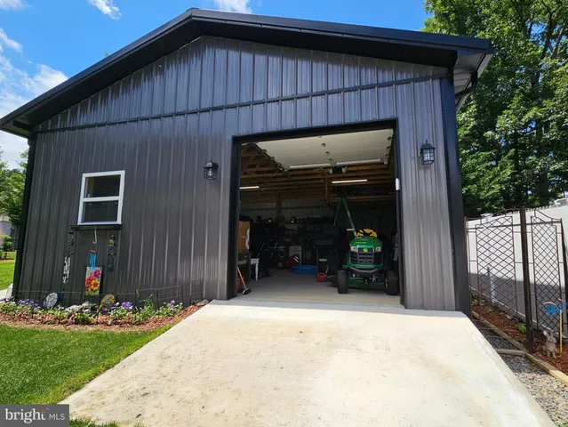 a room with stainless steel appliances kitchen island granite countertop a sink and a refrigerator
