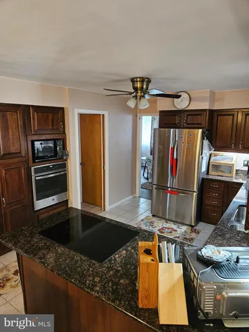 a kitchen with stainless steel appliances granite countertop a sink and a refrigerator