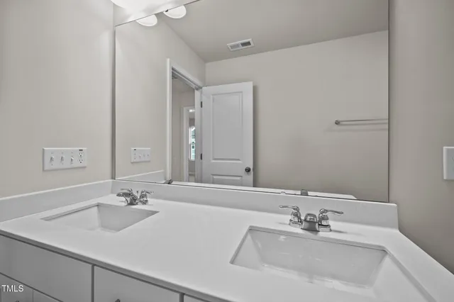 a bathroom with a sink a toilet a mirror and shower