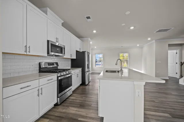 a kitchen with stainless steel appliances granite countertop a sink and a stove