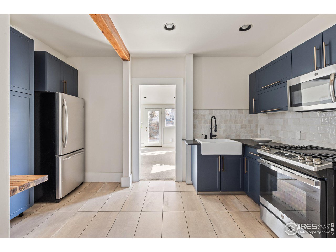 4464 Raleigh Street Denver, CO 80212 - Photo 11 of 39 a kitchen with stainless steel appliances a stove a refrigerator and a sink