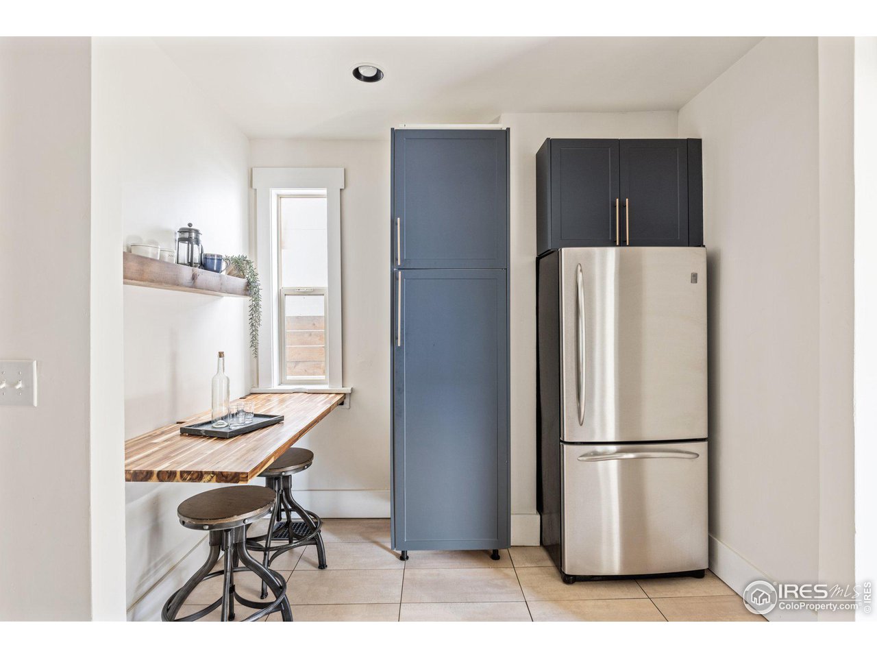 4464 Raleigh Street Denver, CO 80212 - Photo 13 of 39 a kitchen with stainless steel appliances refrigerator stove dining table and chairs