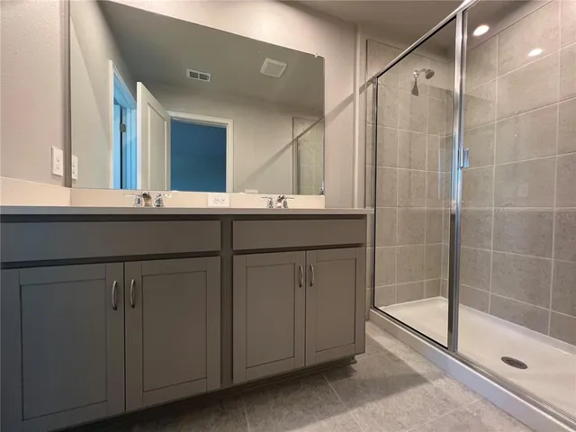 a bathroom with a sink a toilet a mirror and shower