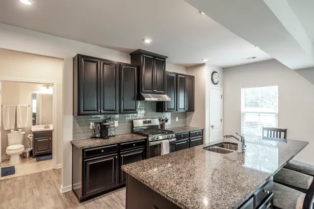 an empty room with wooden floor ceiling fan and windows