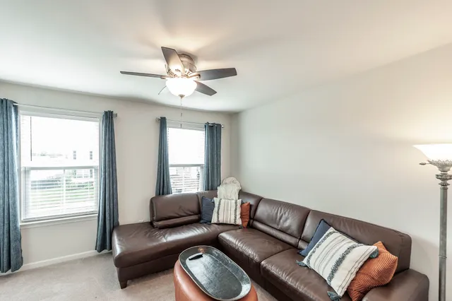 a living room with furniture a window and a lamp