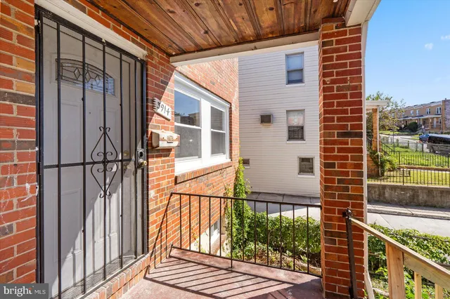 a view of a brick house with many windows next to a road
