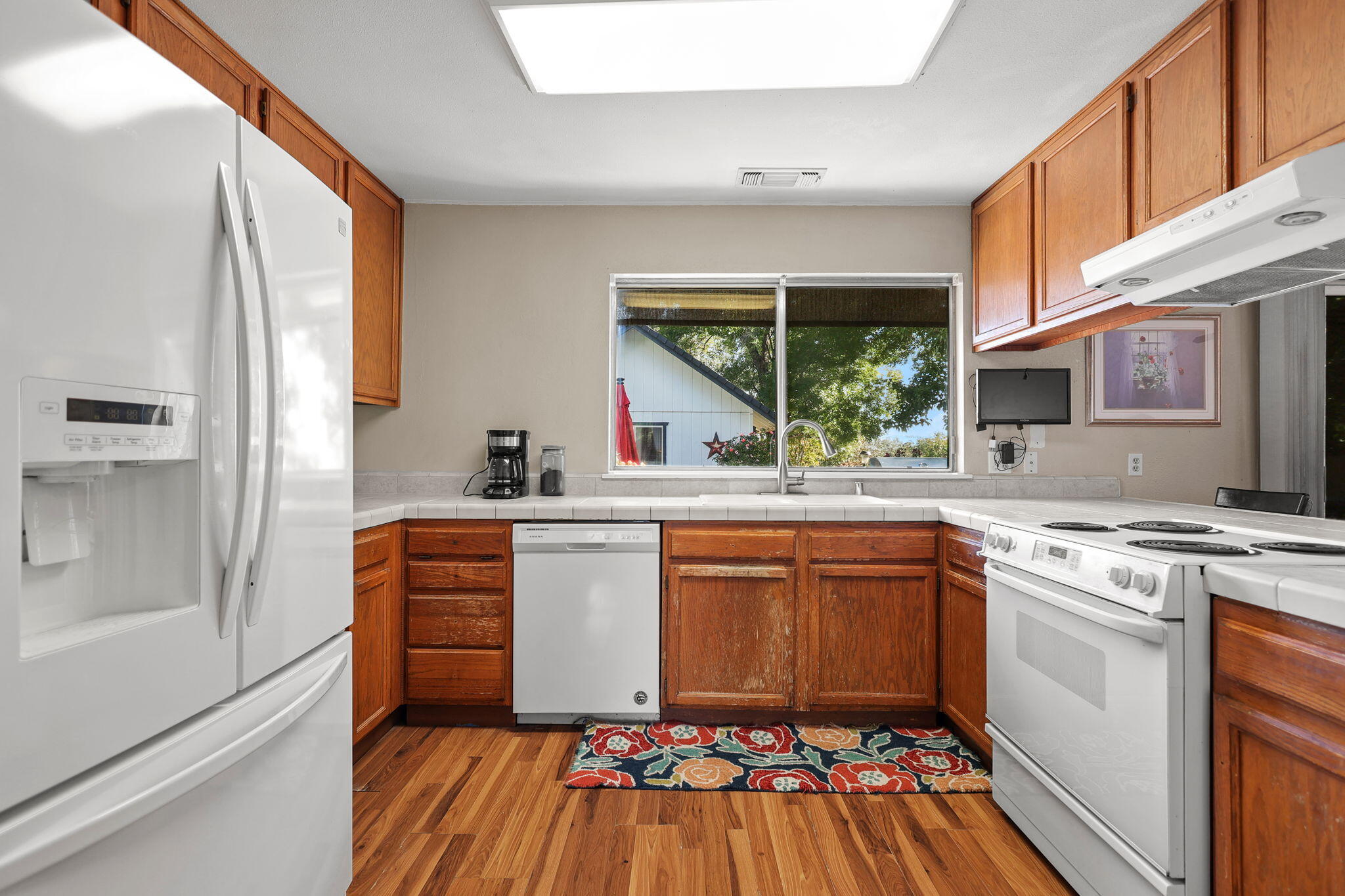 404 Woodhill Drive Redding, CA 96003 - Photo 14 of 52 a kitchen with stainless steel appliances granite countertop a stove a sink and a refrigerator