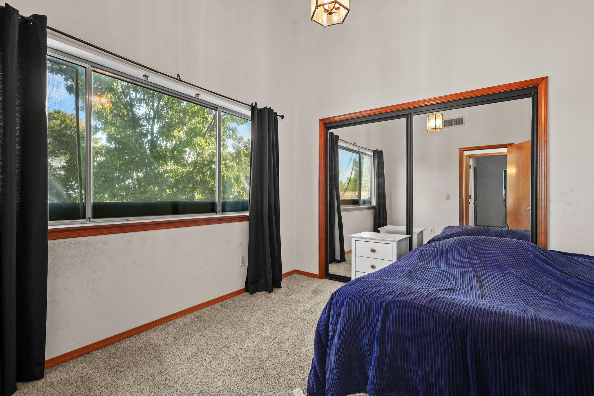 404 Woodhill Drive Redding, CA 96003 - Photo 22 of 52 a bedroom with a bed and a large window