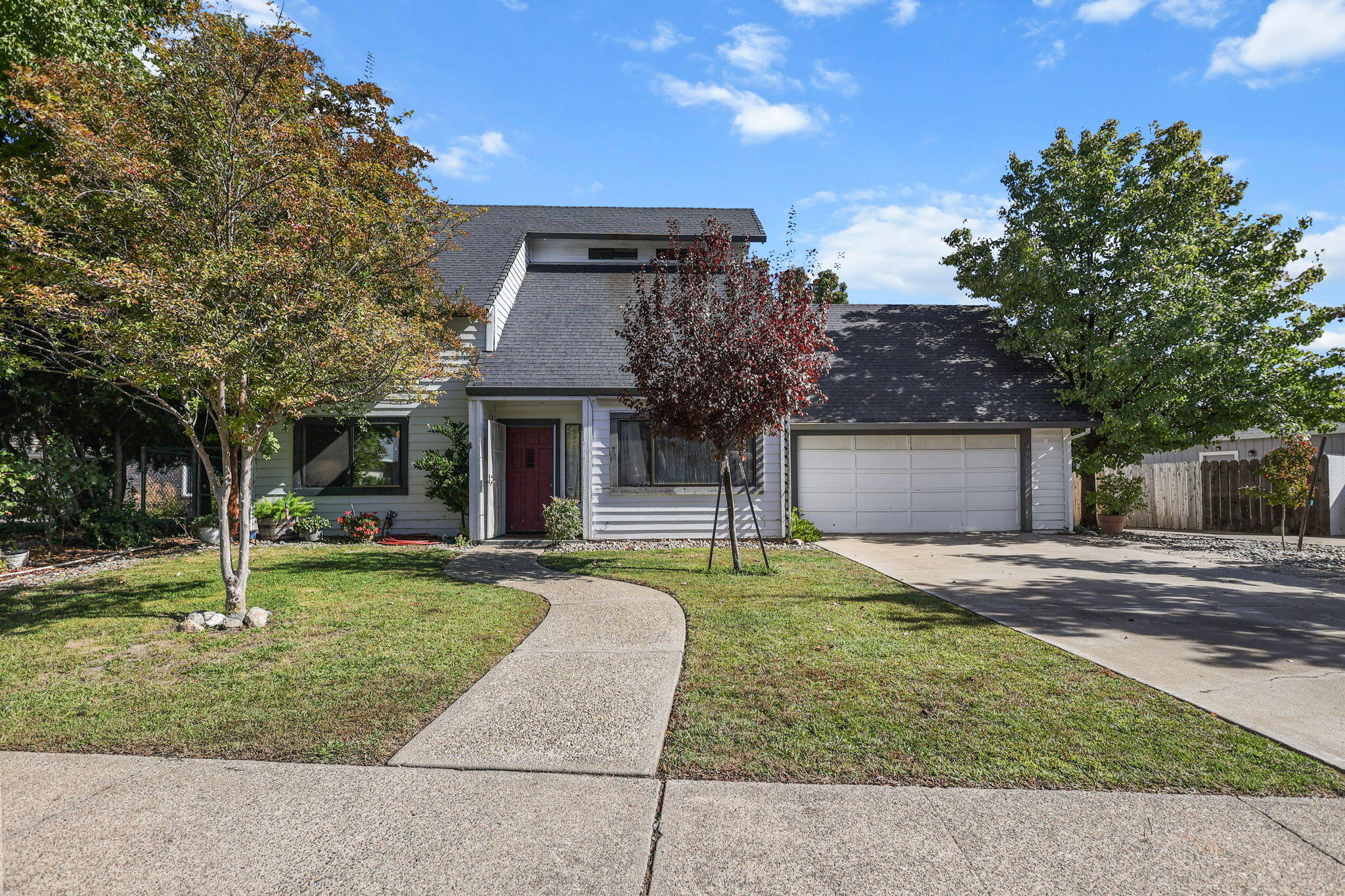 404 Woodhill Drive Redding, CA 96003 - Photo 4 of 52 a front view of a house with a yard and garage