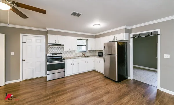 a kitchen with a refrigerator and a stove top oven