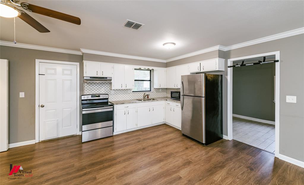 198 7 Pines Road Benton, LA 71006 - Photo 11 of 30 a kitchen with a refrigerator and a stove top oven