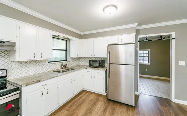 a kitchen with a refrigerator sink and cabinets
