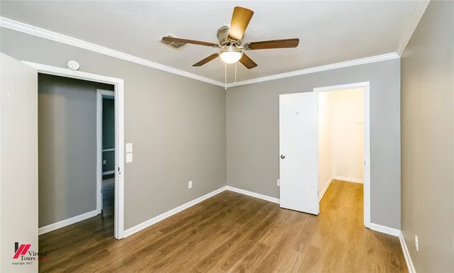 a view of room with wooden floor and ceiling fan