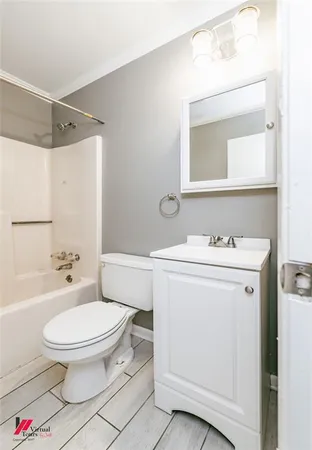 a bathroom with a toilet sink vanity and mirror