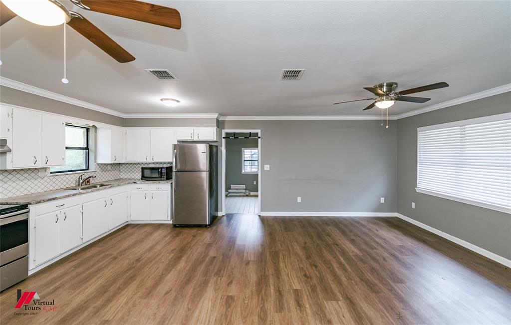 198 7 Pines Road Benton, LA 71006 - Photo 8 of 30 a kitchen with stainless steel appliances granite countertop a refrigerator a sink dishwasher a stove and white countertops with wooden floor