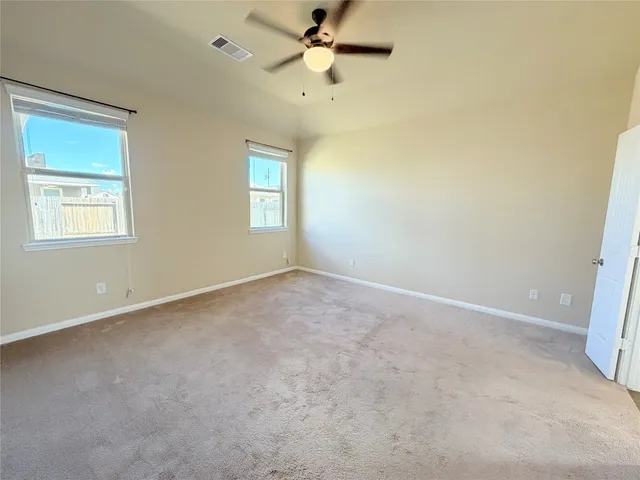 an empty room with a window and a fan