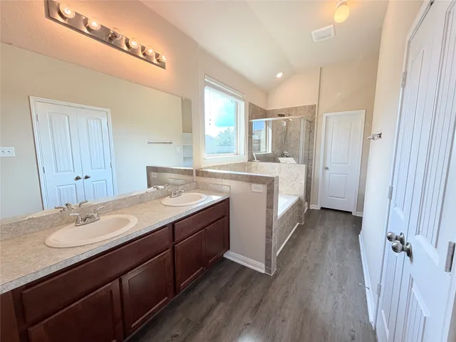 a spacious bathroom with a double vanity sink a mirror and a bathtub