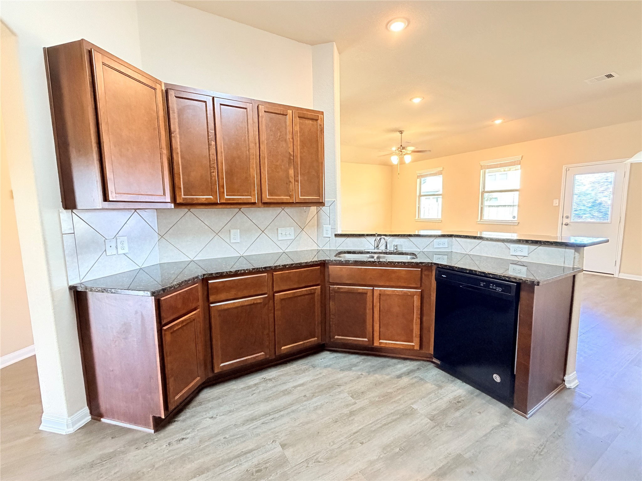 15613 All Star Drive Splendora, TX 77372 - Photo 10 of 25 a kitchen with stainless steel appliances granite countertop wooden cabinets a sink and dishwasher