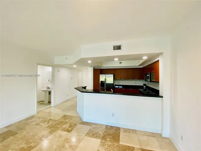 a view of a kitchen with a sink and a refrigerator