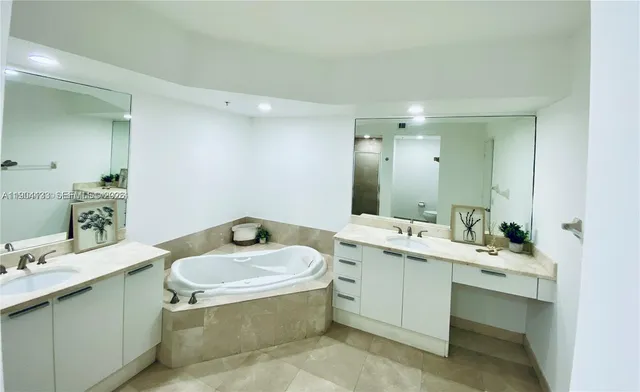 a bathroom with a tub sink and mirror