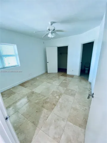 an empty room with a ceiling fan and a window