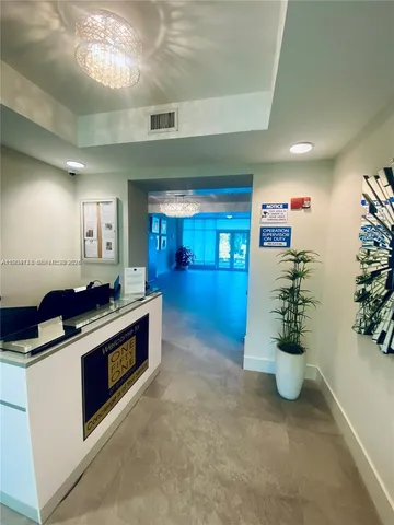 a view of a hallway with wooden floor and a bathroom