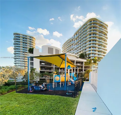 a living room with stainless steel appliances furniture a rug and a view of kitchen