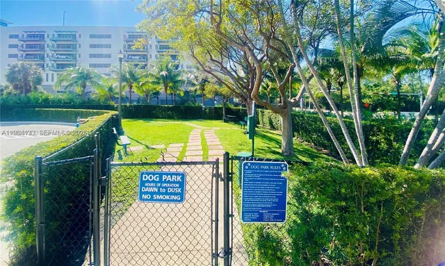 a front view of a residential apartment building with yard and parking space