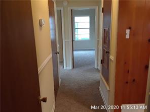 7804 Rutgers Avenue Austin, TX 78757 - Photo 6 of 10 An inviting hallway features classic wood paneling accents and soft carpeting underfoot.