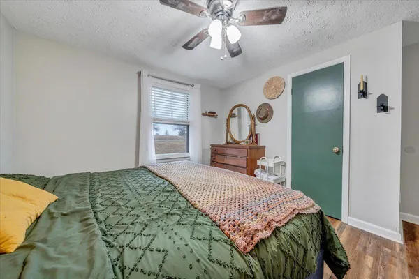 a bedroom with a bed chandelier and a window