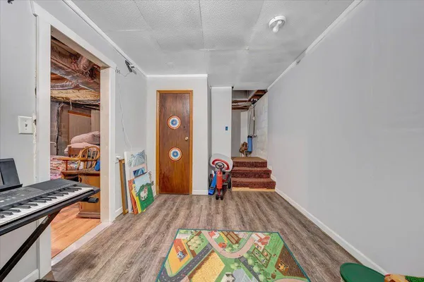 a view of a bedroom with wooden floor and furniture