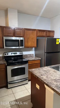 a kitchen with granite countertop a stove and a microwave