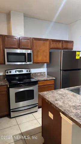 a kitchen with granite countertop a stove and a microwave