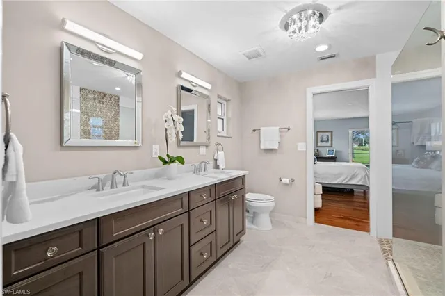 a spacious bathroom with a double vanity sink a large mirror and a bathtub