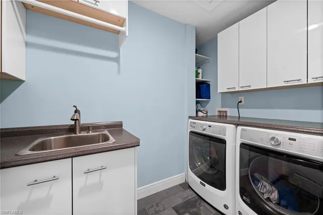 a kitchen with white cabinets sink and stainless steel appliances