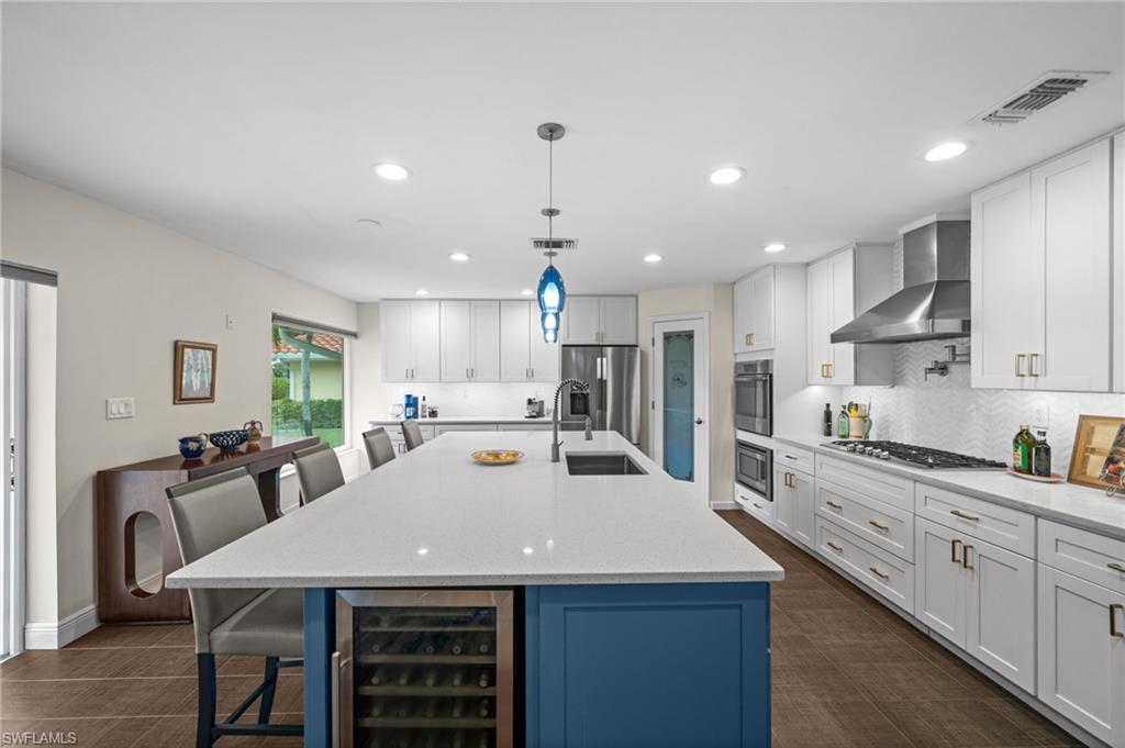 1960 Imperial Golf Course Boulevard Naples, FL 34110 - Photo 10 of 38 Chef’s kitchen with solid wood cabinetry, quartz countertops, and oversized island