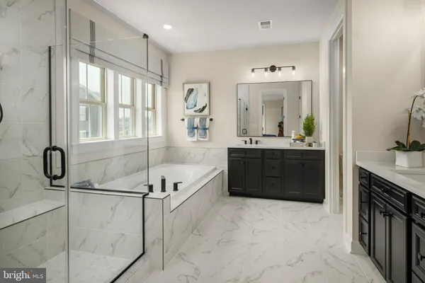 a spacious bathroom with a tub sink and mirror