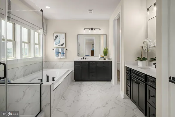 a spacious bathroom with a tub sink and mirror