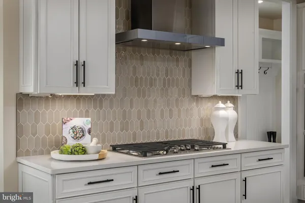 a kitchen with white cabinets and a stove