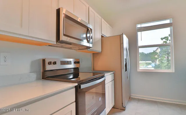 a kitchen with stainless steel appliances granite countertop a stove a microwave and a refrigerator