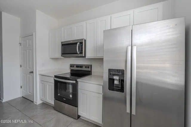 a kitchen with a refrigerator stove and microwave