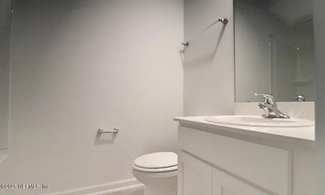 a bathroom with a sink toilet and a mirror