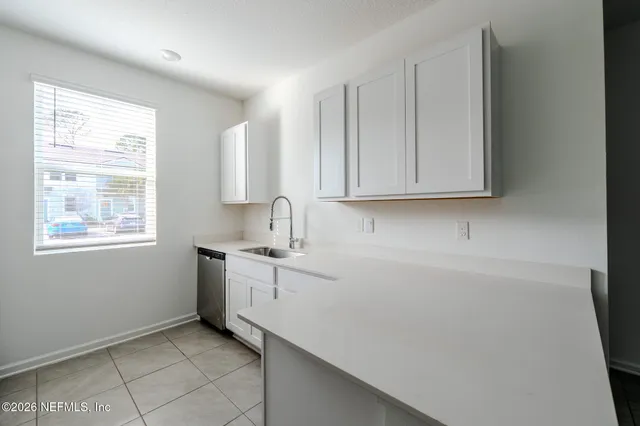 a room with a sink cabinets and a window